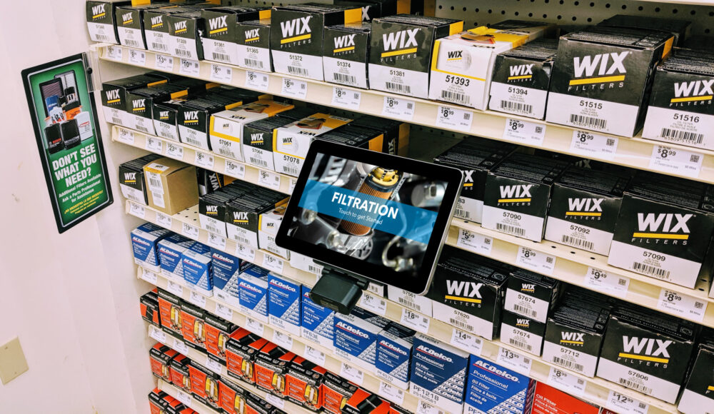 A digital display stand on a retail aisle unit